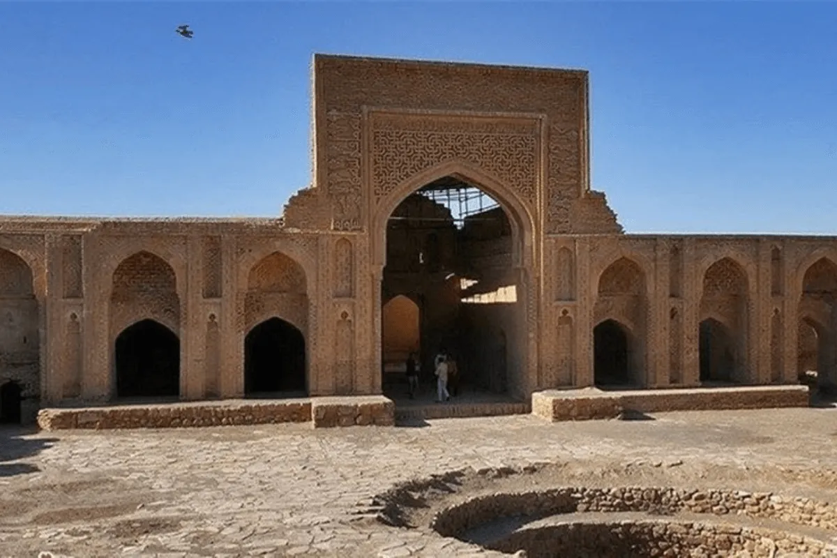 historic caravanserai with arched entrance, stone walls, and a courtyard surrounded by rooms for travelers
